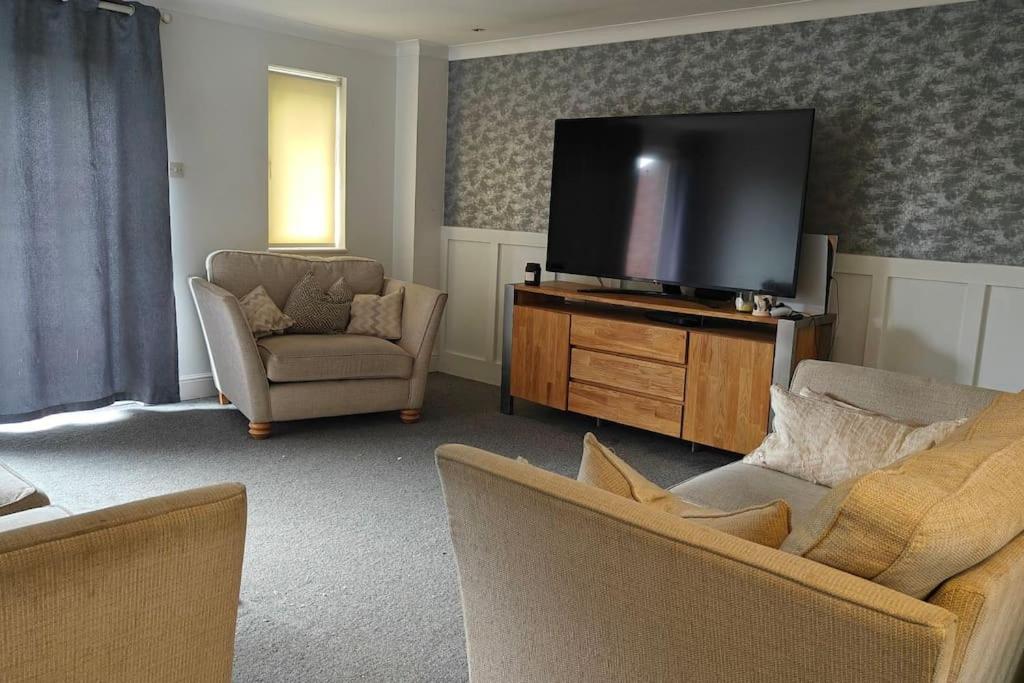 sala de estar con TV de pantalla plana y 2 sillas en Property near Marina & Leisure en Portsmouth