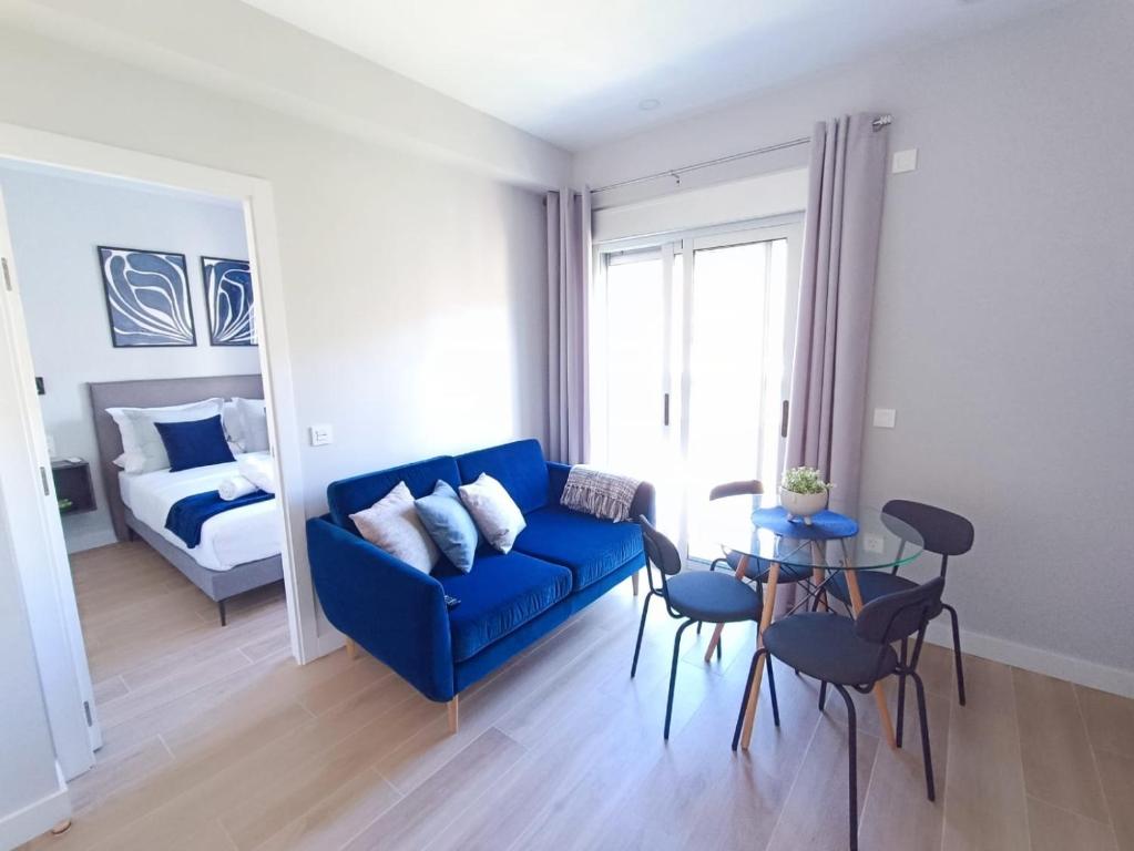 un soggiorno con divano blu e letto di RAMBLA DREAMS Nuevo apartamento céntrico y 1GB a Santa Cruz de Tenerife