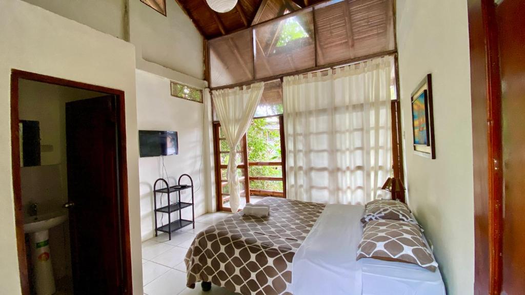 a bedroom with a bed and a large window at Hotel Sumpa in Montañita