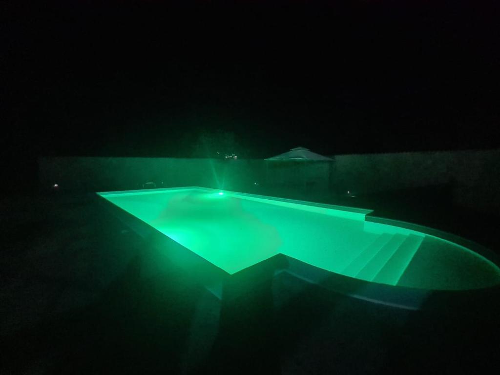 een zwembad met verlichting in het donker bij VILLA MINOLFI in Piazza Armerina