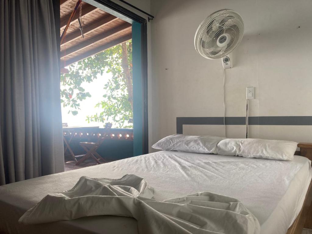een slaapkamer met een bed, een ventilator en een raam bij Hotel Punta Faro in Necoclí