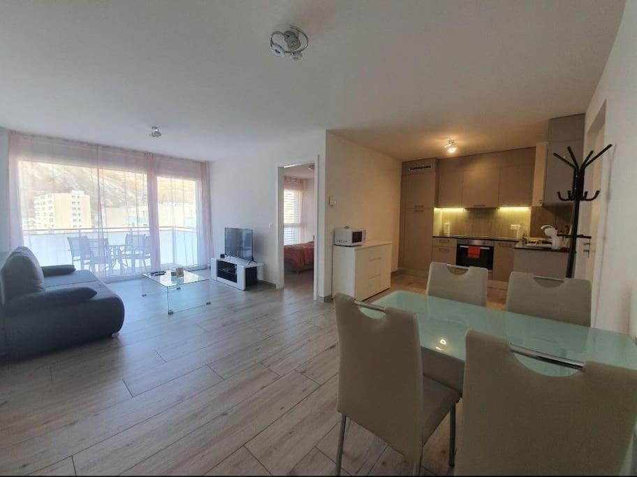 a living room with a table and chairs and a kitchen at Jacqueline residence in Sion