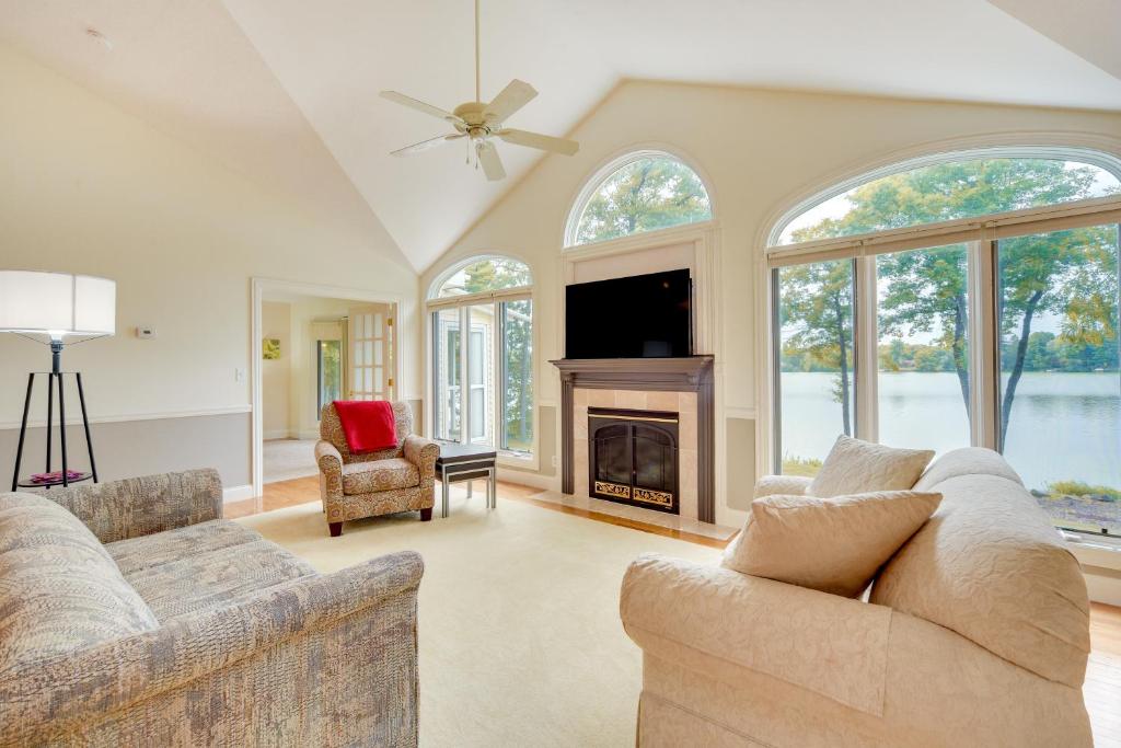 a living room with a couch and a fireplace at Spacious Lakefront New Auburn Home with Sunroom in Chetek