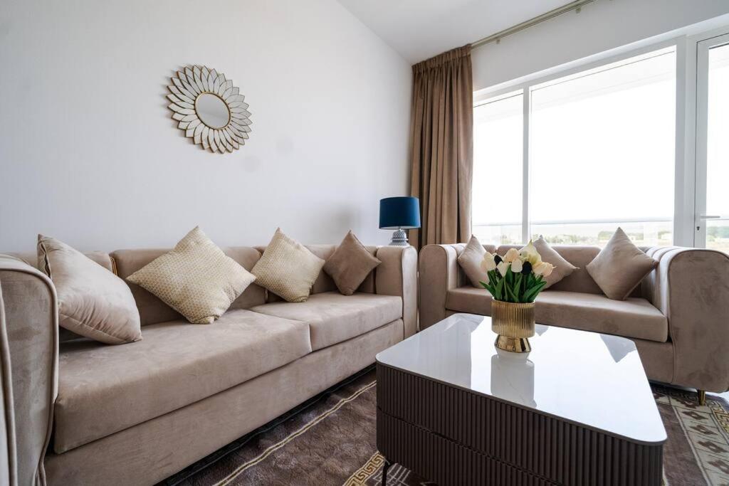 ein Wohnzimmer mit einem Sofa und einem Tisch in der Unterkunft Elegant 2BR near Palm Jumeirah - 6 Min Drive in Dubai