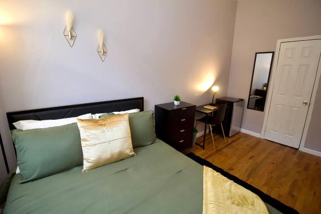 a bedroom with a bed with green sheets and a mirror at Tuk Ahoy - Emerald Suite 3C with Shared Spaces in Brooklyn