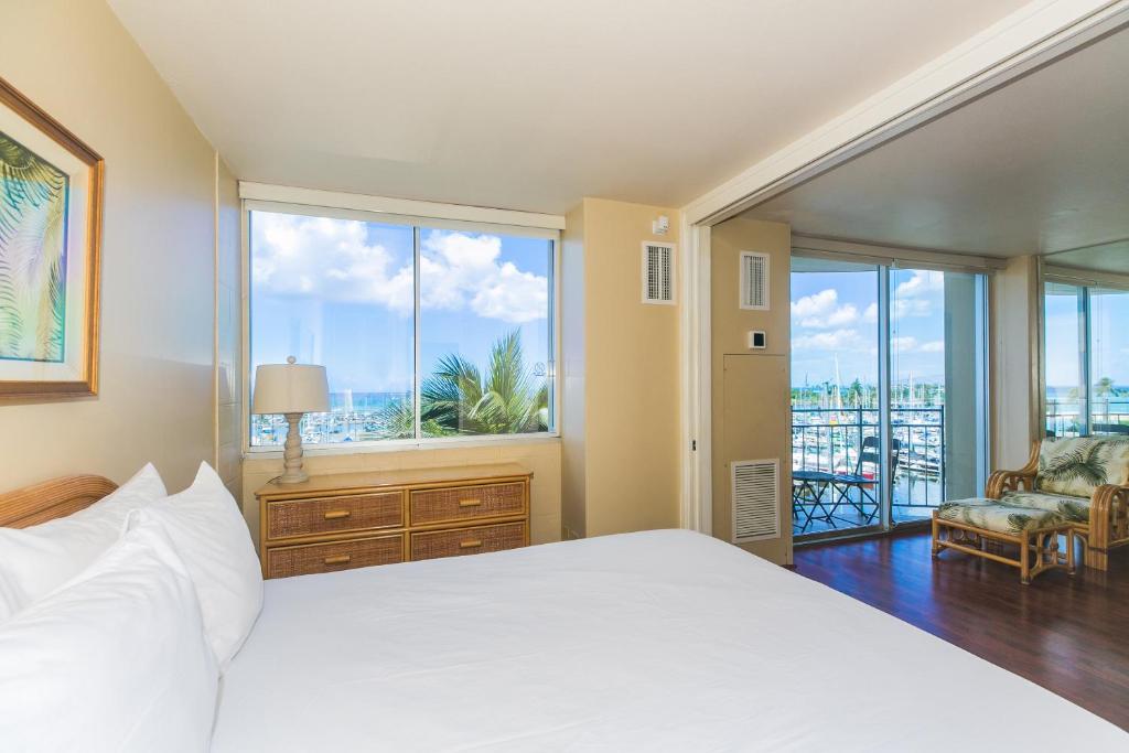 um quarto com uma cama e uma grande janela em Ilikai Marina 682 Yacht Harbor View 1BR em Honolulu