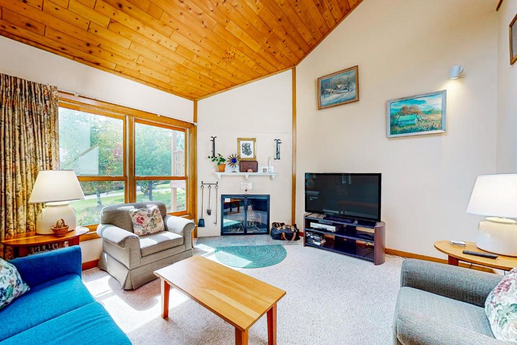a living room with a couch and a tv at Trail Creek 42 in Killington