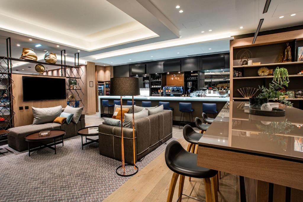 a living room with a bar in a hotel at Courtyard by Marriott Paris Porte de Versailles in Issy-les-Moulineaux