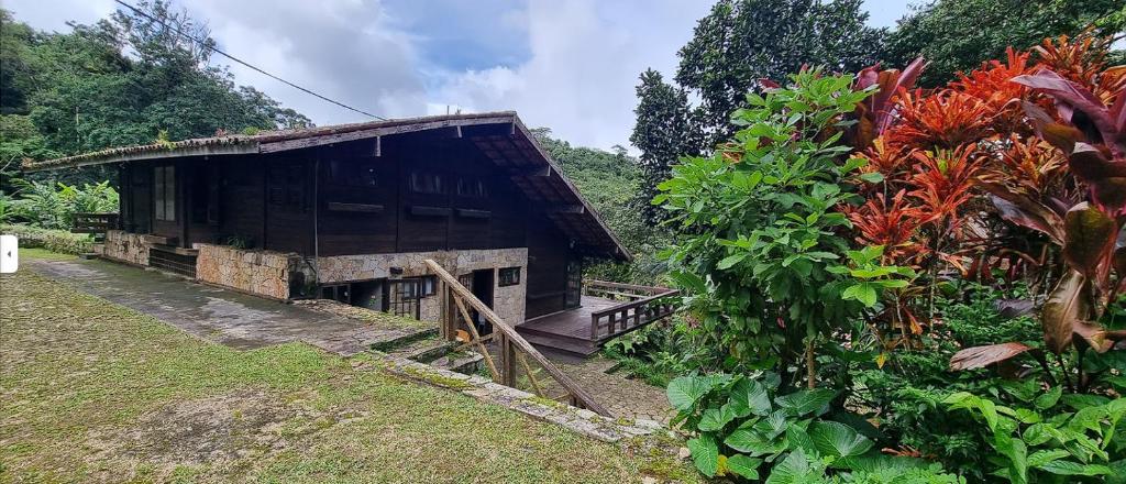 un edificio con una valla junto a un jardín en Chalé das Helicônias en Guaramiranga