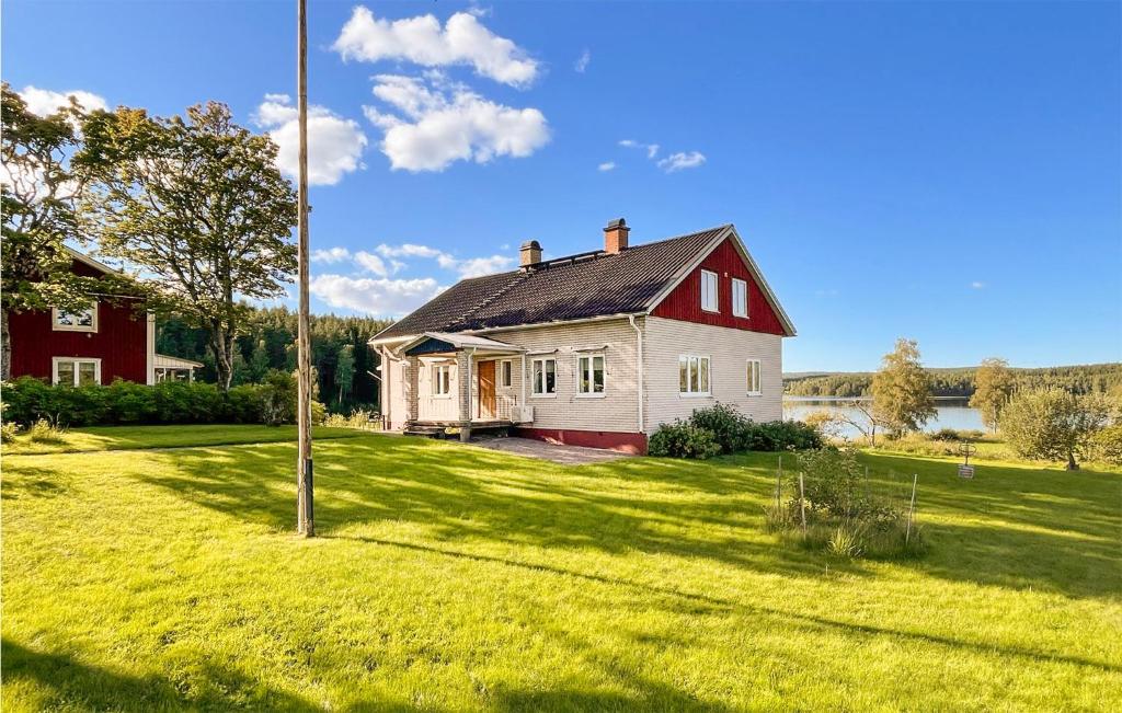 a red and white house in a grassy yard at Stunning Home In Klssbol With Kitchen in Klässbol
