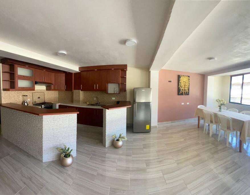 a large kitchen with a counter and a dining room at Elsita departamento vacacional in Baños