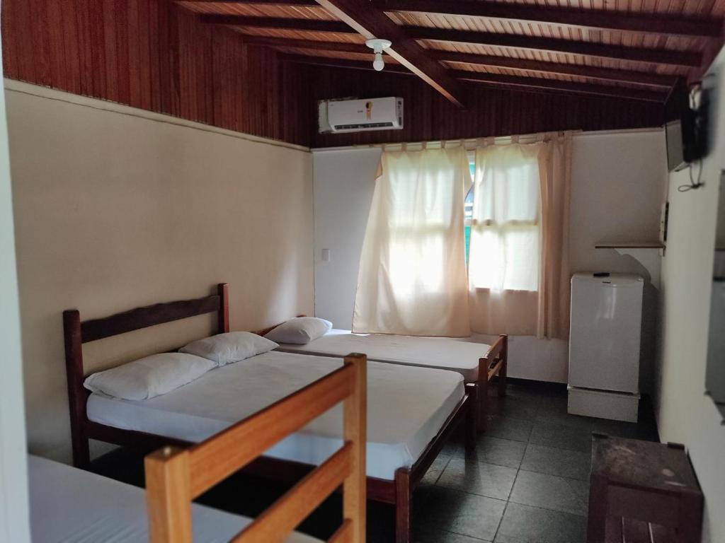 ウバトゥバにあるChales Mata Atlantica De Ubatubaのベッド2台と窓が備わる客室です。
