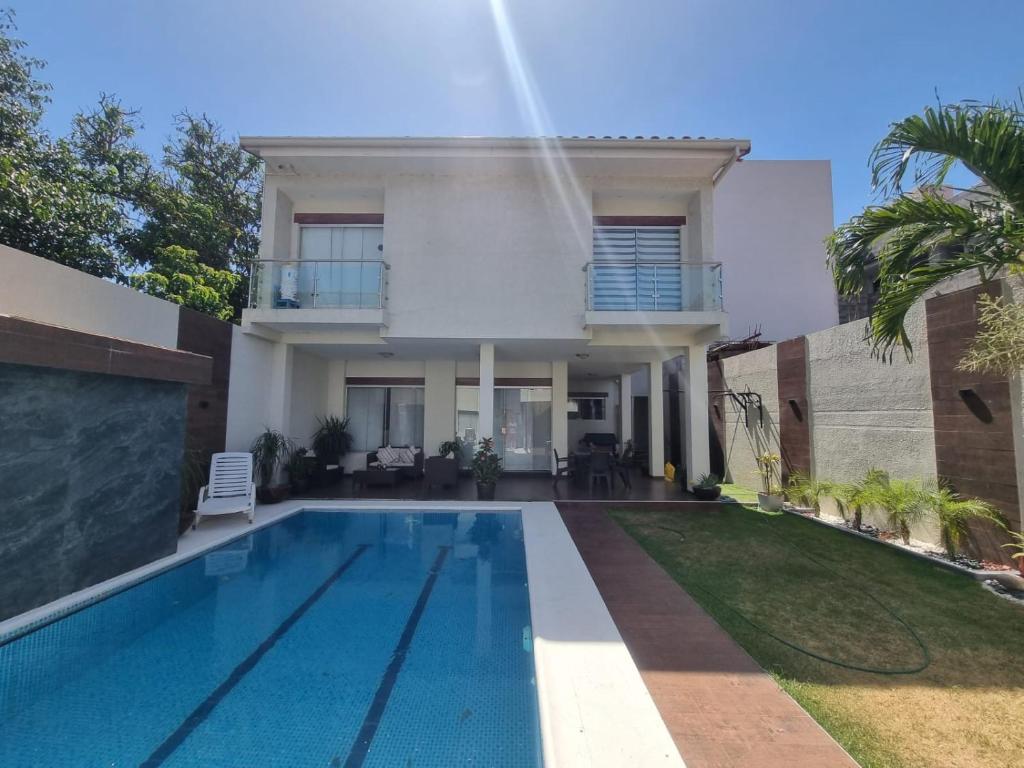 uma casa com piscina em frente a uma casa em Tourist House em Santa Cruz de la Sierra