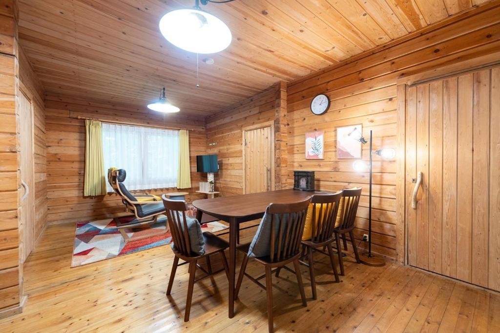 een eetkamer met een tafel en stoelen bij S-villa Karuizawa wood creek in Tsumagoi