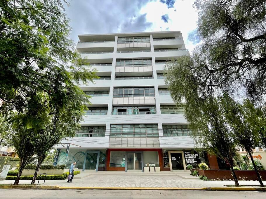 un grande edificio bianco con alberi di fronte di Sisters- Apartamento cómodo y familiar a Cochabamba