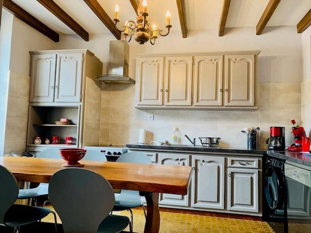cocina con armarios blancos y mesa de madera en Appartement Amélie-les-Bains-Palalda, 2 pièces, 2 personnes - FR-1-703-153, en Amélie-les-Bains-Palalda