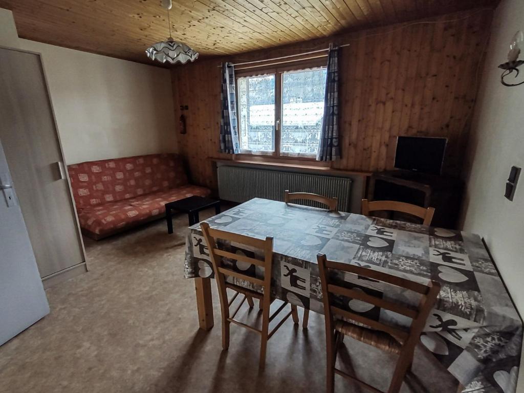 une salle à manger avec une table, des chaises et un canapé dans l'établissement Charmant appartement à Les Gets - 5 pers, 3 pièces, proche remontées mécaniques et services - FR-1-671-25, aux Gets
