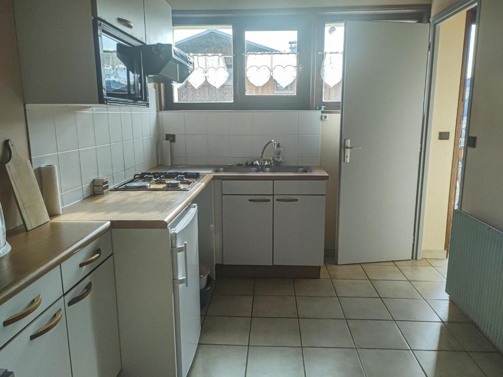 a kitchen with a sink and a stove top oven at Appartement Les Gets, 3 pièces, 5 personnes - FR-1-671-25 in Les Gets
