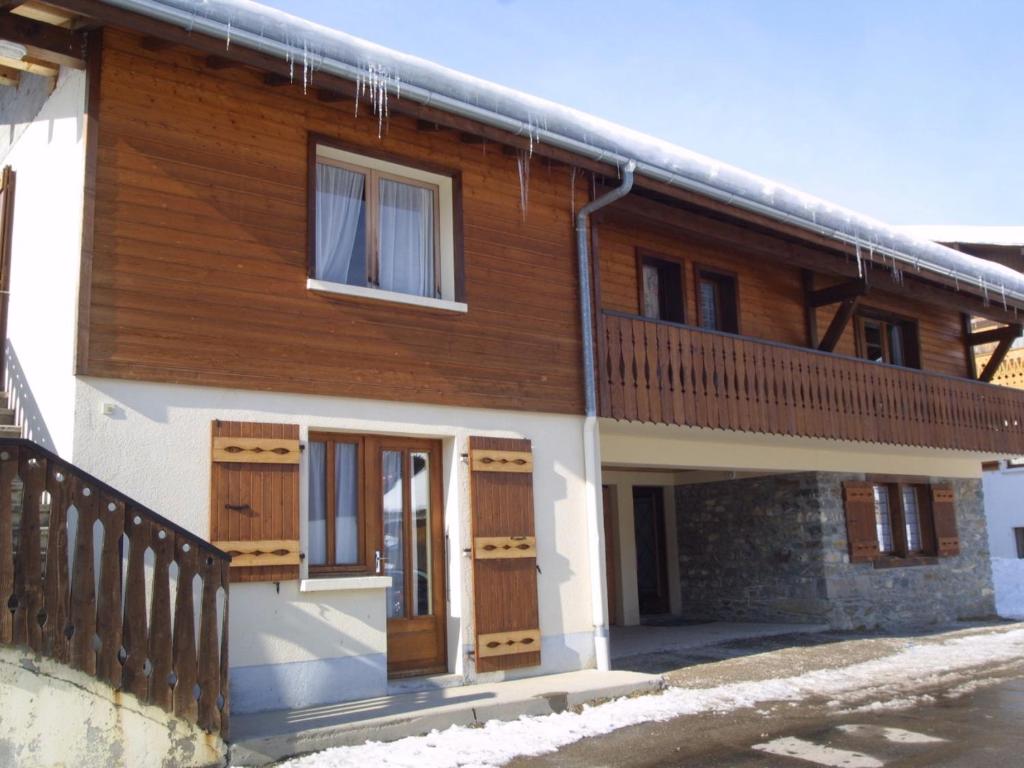 a house with wooden doors and a balcony at Appartement Les Gets, 3 pièces, 5 personnes - FR-1-671-25 in Les Gets