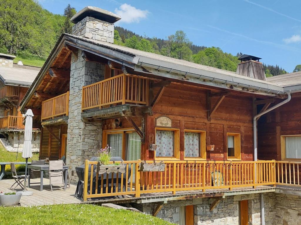une cabane en rondins avec une véranda et une terrasse dans l'établissement Chalet spacieux avec sauna, 4 chambres et Wi-Fi - FR-1-671-50, aux Gets