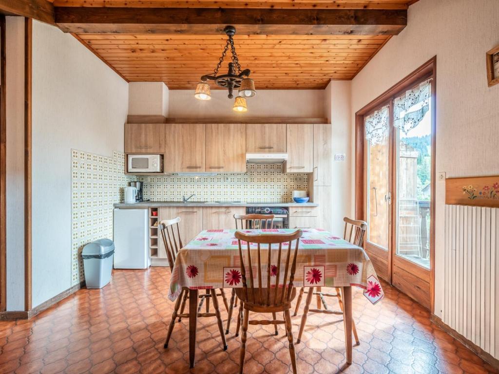 une cuisine avec une table et des chaises dans une pièce dans l'établissement Charmant appartement avec WiFi, parking et animaux admis - FR-1-671-77, aux Gets