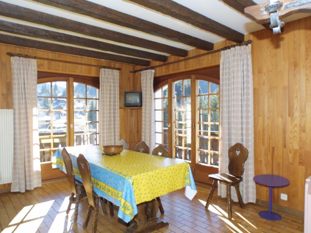 d'une salle à manger avec une table et quelques fenêtres. dans l'établissement Appartement familial avec balcon, proche télécabines et centre, garage, animaux admis - Les Gets - FR-1-671-41, aux Gets