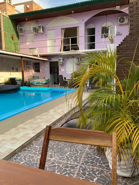 a bench in front of a house with a swimming pool at Residencial Napolitan in Manaus