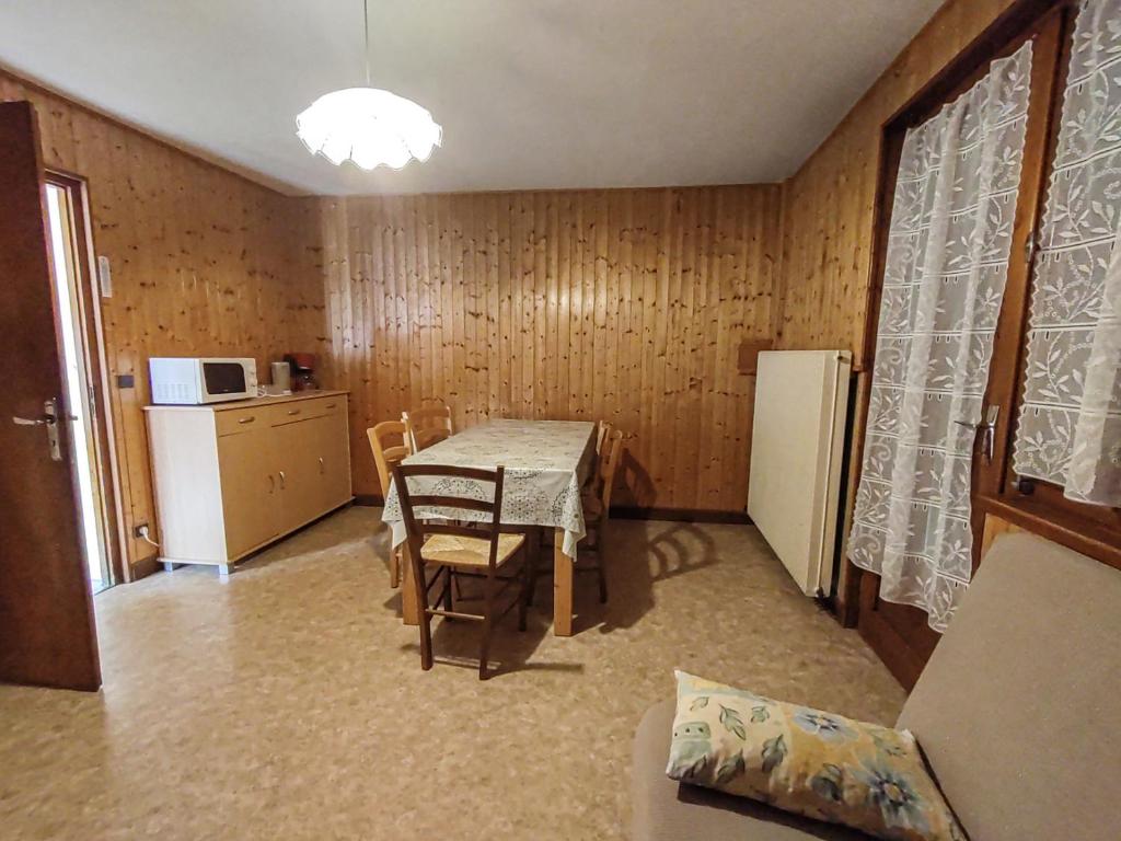une salle à manger avec une table et une cuisine dans l'établissement Appartement cosy aux Gets - Idéal famille - Proche pistes - Animaux admis - FR-1-671-74, aux Gets