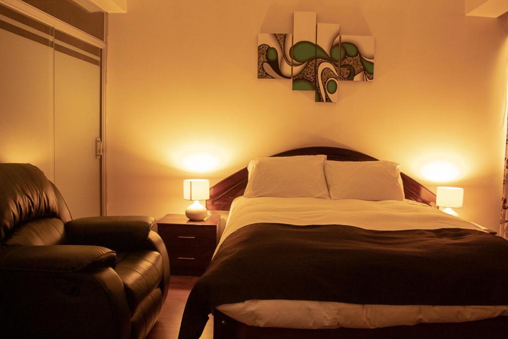 een slaapkamer met een groot bed en een bank bij Hotel B&V in Huancayo