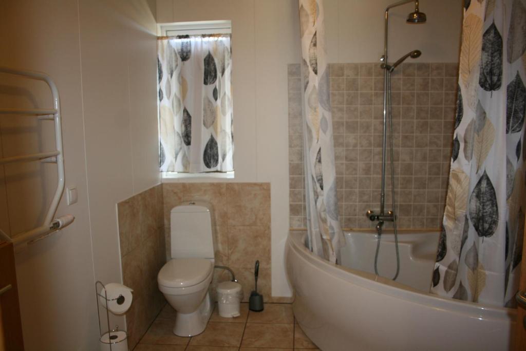 a bathroom with a tub and a toilet and a sink at Litlabjarg Guesthouse in Hrafnabjorg