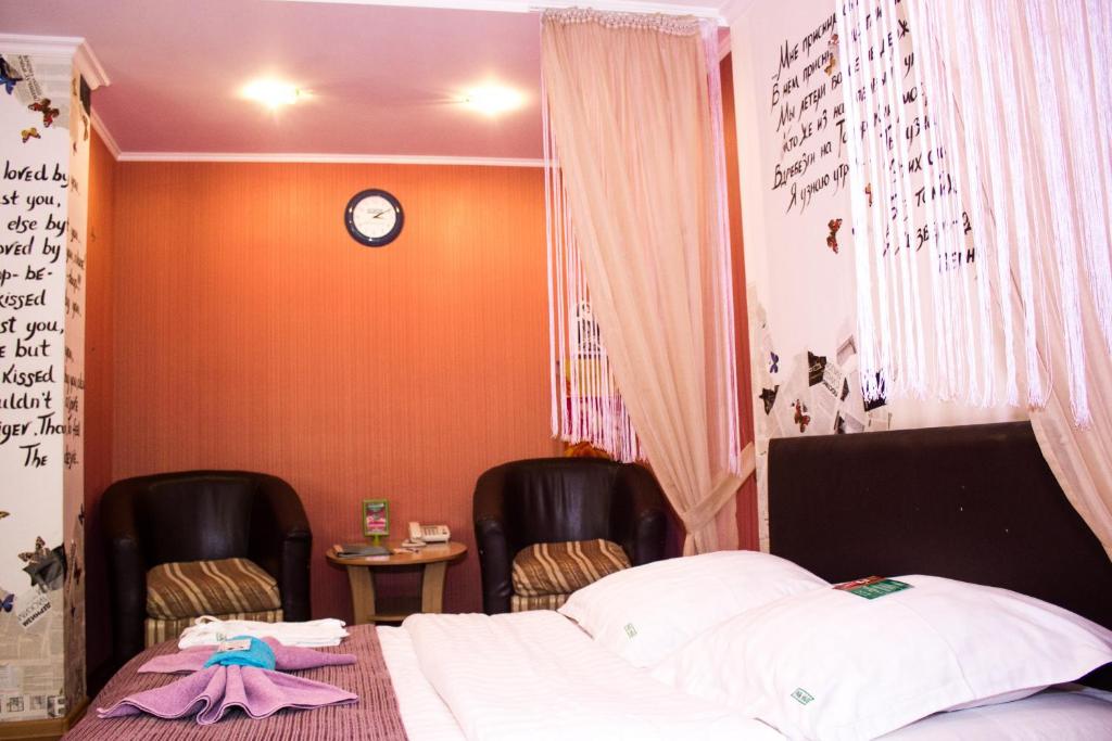 a bedroom with two chairs and a bed at LONDON in Petropavlovsk