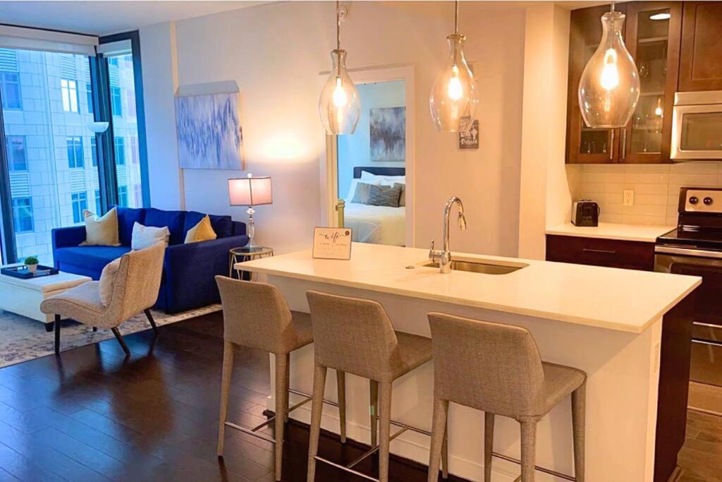 a kitchen and living room with a kitchen island with chairs at The Luxe -Highrise, Balcony, Pool, City View! in Atlanta