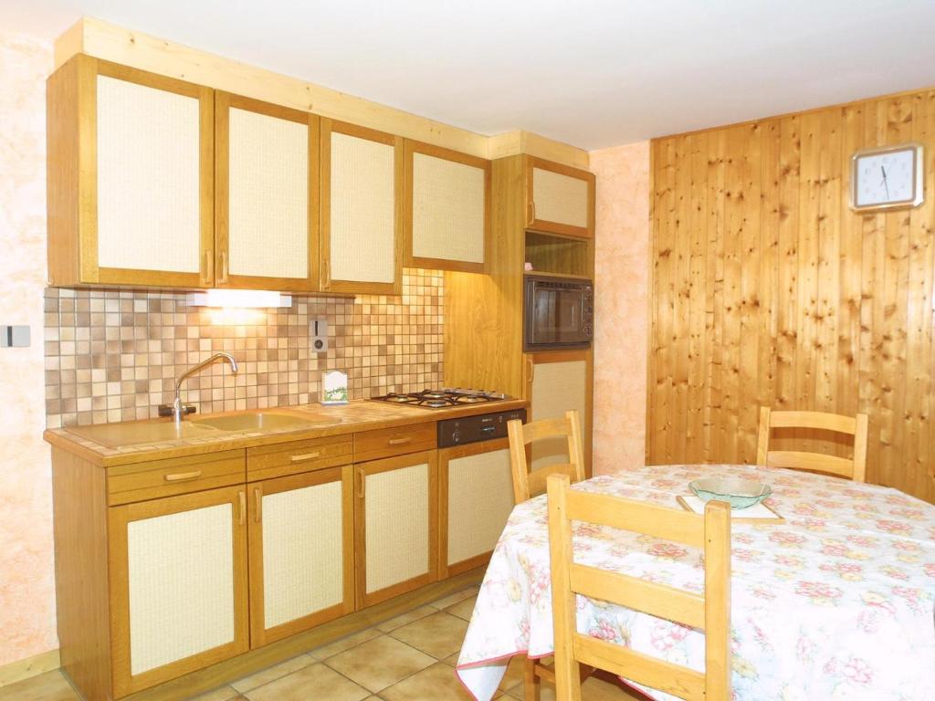une cuisine avec une table et un évier et une table et des chaises dans l'établissement Studio cosy, 3 pers, centre Les Gets, Wi-Fi, parking, proche télécabines, non fumeur. - FR-1-671-90, aux Gets