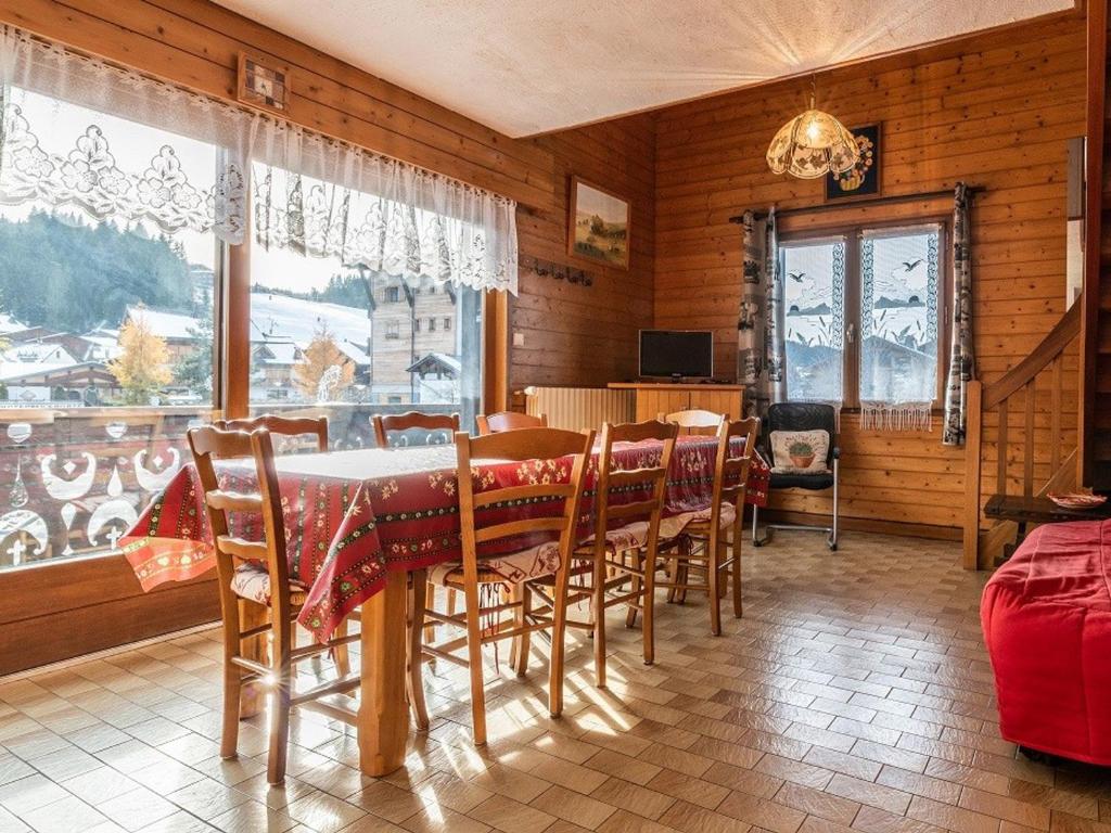 une salle à manger avec une table et des chaises et une fenêtre dans l'établissement Appartement aux Gets avec WiFi et animaux admis - FR-1-671-100, aux Gets