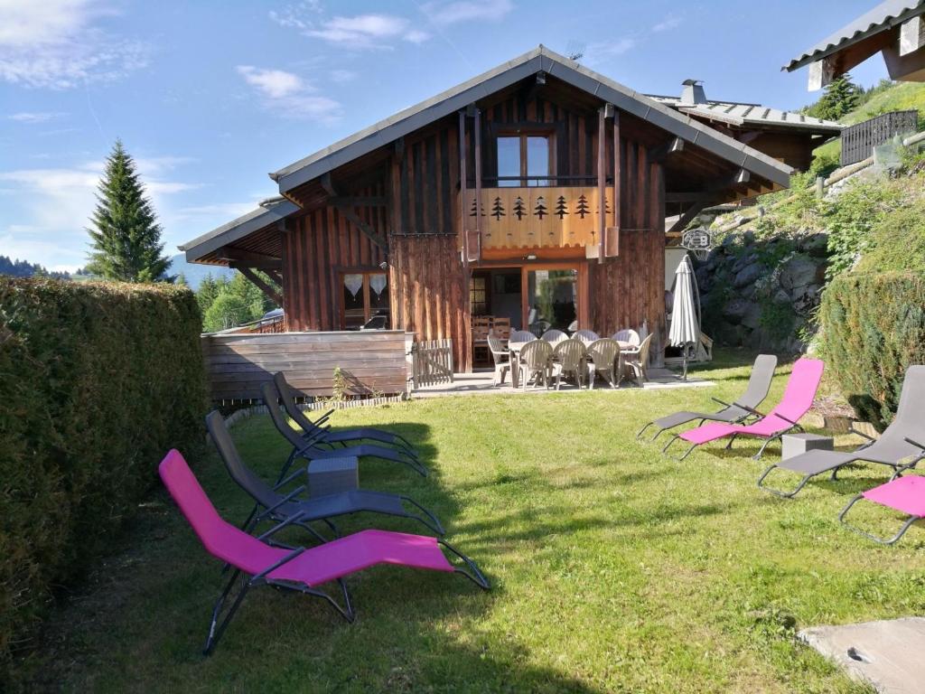 un groupe de chaises de jardin devant une maison dans l'établissement Chalet spacieux aux Gets avec cheminée, WiFi et animaux admis - FR-1-671-128, aux Gets