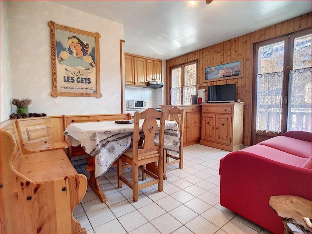 - une cuisine et une salle à manger avec une table et un canapé dans l'établissement Location cosy aux Gets - 4 pers, 2 pièces, proche ski et centre - FR-1-671-149, aux Gets