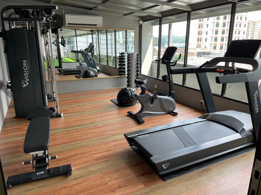 A bright, window-lined fitness room with cardio and strength equipment.