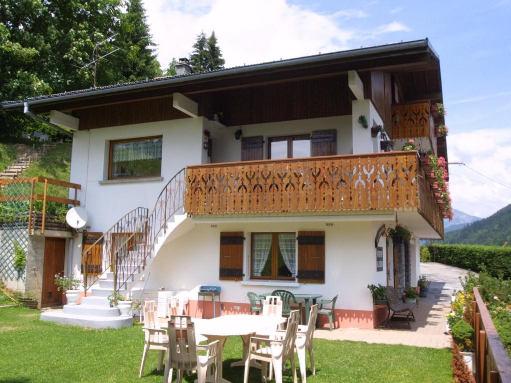une maison avec un balcon, des tables et des chaises dans l'établissement Appartement cosy aux Gets avec Wi-Fi et parking privé - FR-1-671-97, aux Gets