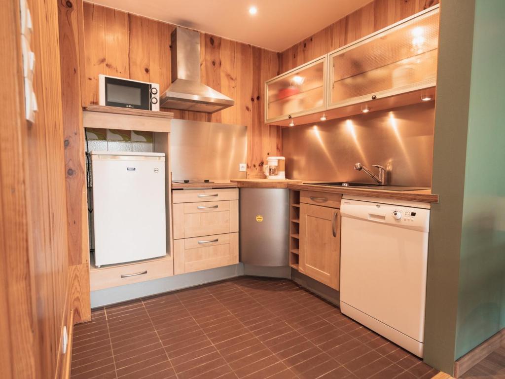 a kitchen with wooden cabinets and a white refrigerator at Appartement Les Gets, 2 pièces, 3 personnes - FR-1-671-120 in Les Gets