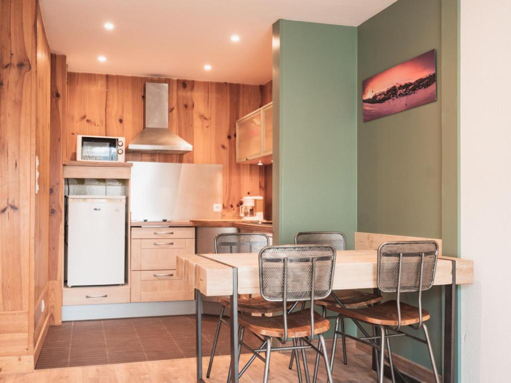 a kitchen with wooden walls and a table and chairs at Appartement Les Gets, 2 pièces, 3 personnes - FR-1-671-120 in Les Gets