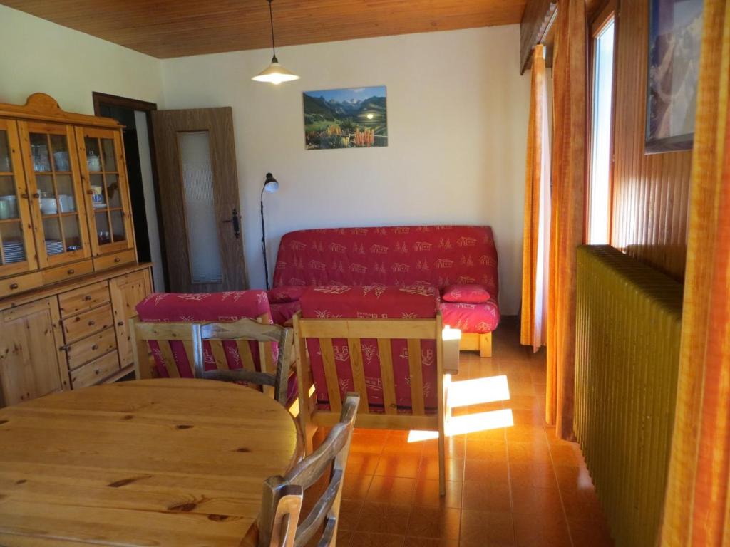 a living room with a table and a red couch at Appartement Les Gets, 3 pièces, 6 personnes - FR-1-671-228 in Les Gets