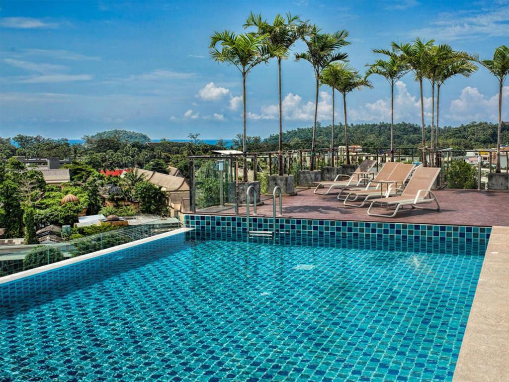 a swimming pool on top of a building with palm trees at Superbe Studio avec Salle De Bain Privee Kata Beach Phuket Phuket in Kata Beach