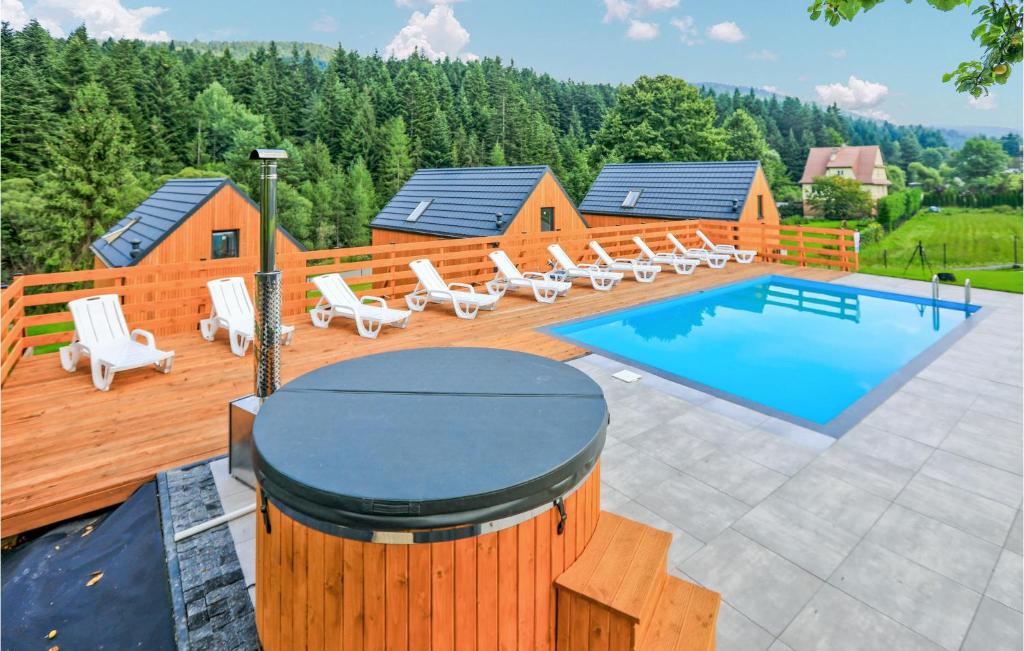 um deque com piscina e espreguiçadeiras ao lado de uma casa em 2 Bedroom Gorgeous Home In Slopnice em Słopnice