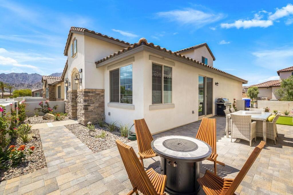 a patio with chairs and a grill in front of a house at PGA West -3 bdrm house w/Bonus Loft, Sleeps 8, Pool, Gym in La Quinta