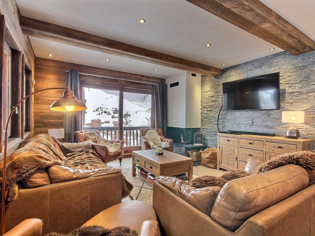Una sala de estar con dos sofás y un televisor de pantalla plana. en Chalet rénové au pied des pistes avec balcon et cheminée - FR-1-455-231, en La Plagne Tarentaise