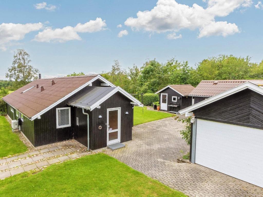 une maison avec un garage et une allée dans l'établissement Holiday home Højslev, à Højslev