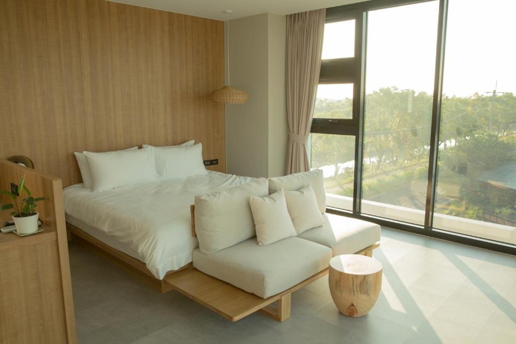 1 dormitorio con cama, sofá y ventana en Golden Harvest Homestay, en Toucheng