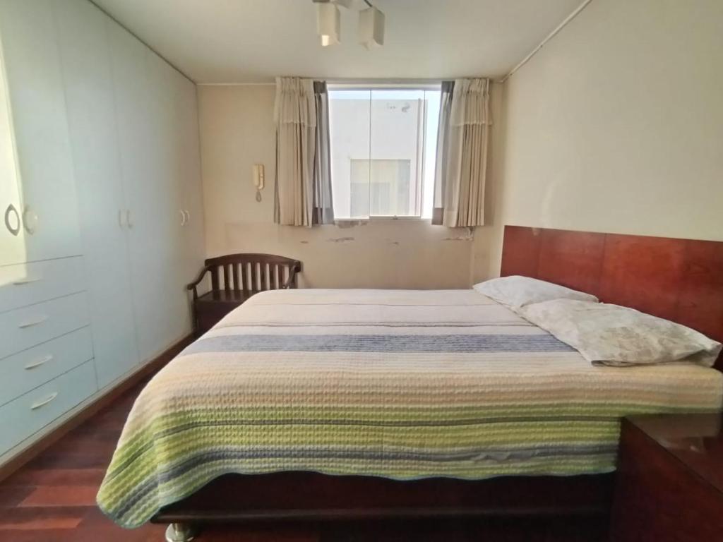 Un dormitorio con una cama grande y una ventana en Departamento duplex en JLByR en Arequipa