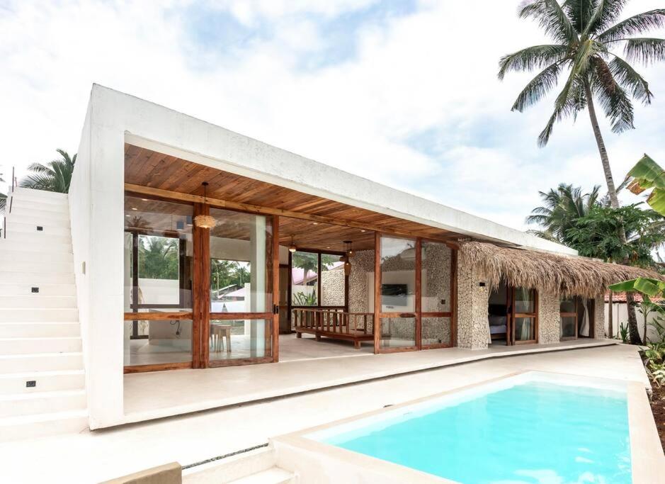 a villa with a swimming pool and a house at Villa Baleia Siargao in San Isidro
