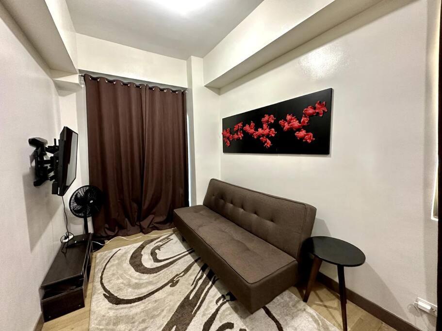 una sala de estar con sofá y una pintura en la pared en Staycation at Spring Residences in Paranaque, en Manila